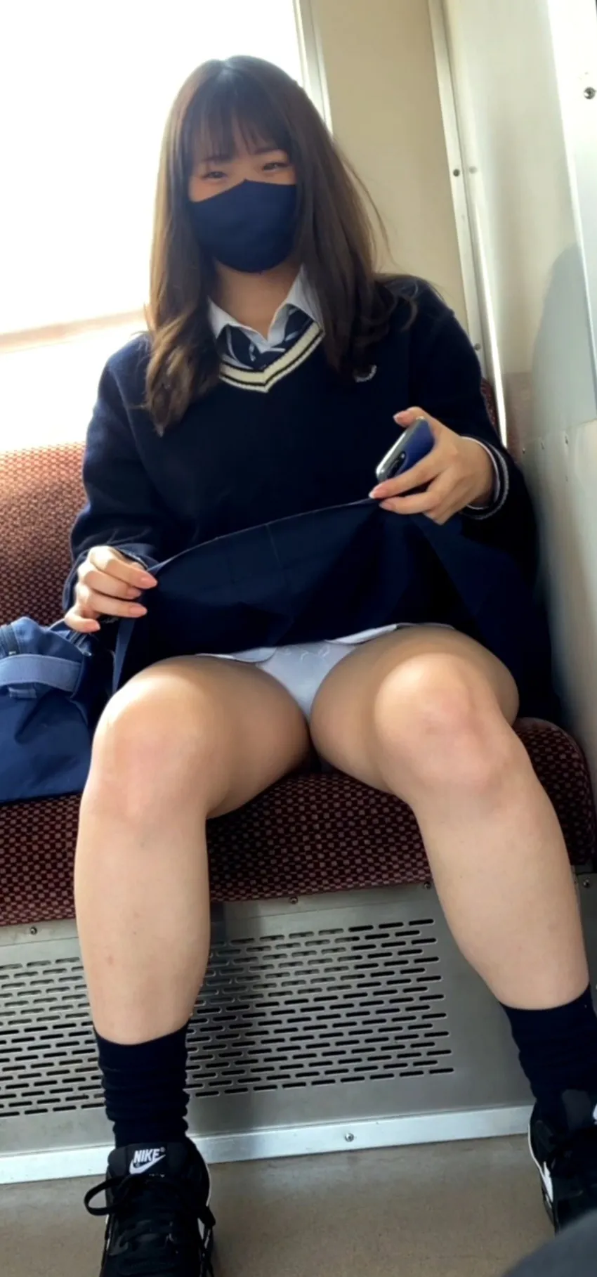 カメラ目線でスカートをめくってパンティを見せるJK