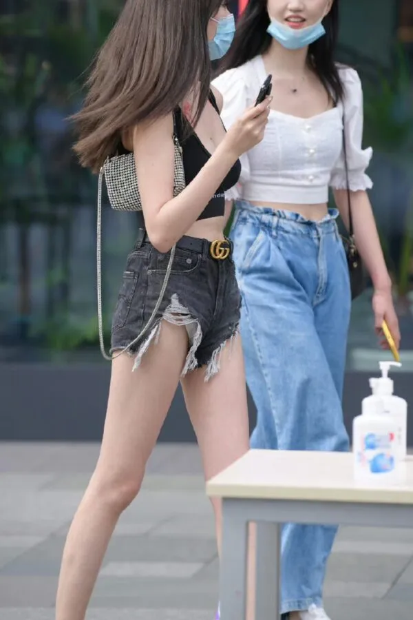 黒いデニムのショートパンツの股間からパンティをチラ見せしながら街を歩く女3