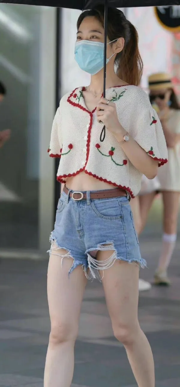 デニムのショートパンツの股間から白いパンティがパンチラしてるのに気づいてない女の写真3