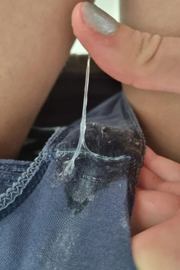青いパンティの股間に透明なマン汁がべっとり付着し、指で引き伸ばされているドアップ画像