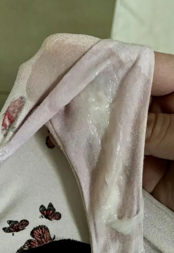 女が手に持った薄ピンク色のパンティの股間部分にドロっとしたマン汁とオリモノがべっとり付着している様子が写っている。