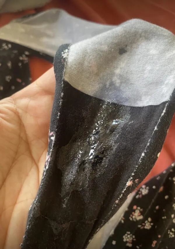 黒いパンティのクロッチ部分に白濁したマン汁とオリモノがべっとり付着している写真