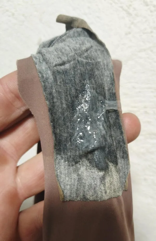 手に持たれた茶色のパンティのクロッチ部分にマン汁とオリモノが鼻水のように濃厚にべっとり付着している様子が写されている。