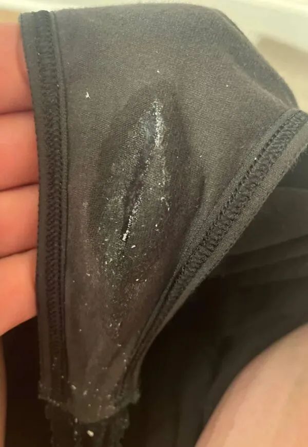 黒いパンティの股間部分にオリモノとマン汁が染みつき、女の淫乱な証しとして鮮明に映し出されている一枚