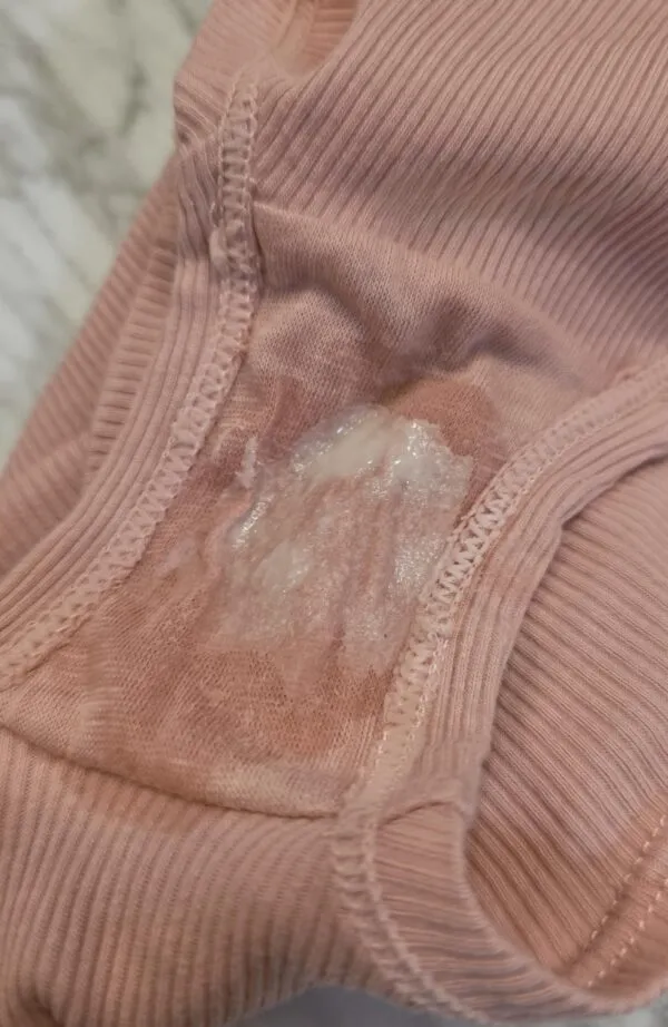 ピンク色のパンティのクロッチ部分に白濁したマン汁とオリモノがべっとり付着している写真