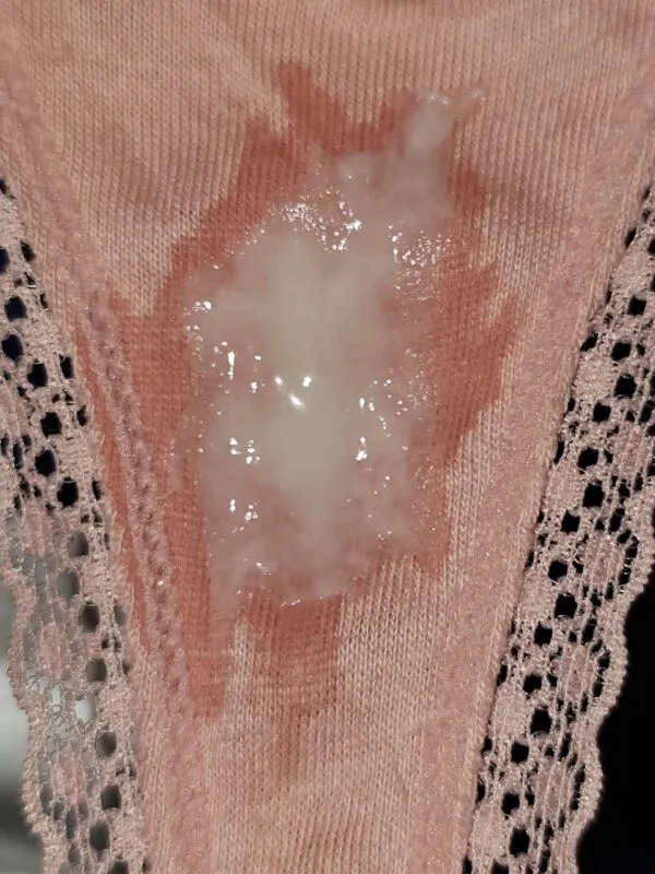 ピンクのレース付きパンティの股間部分に白濁したオリモノがべっとり付着した女の淫乱な股間のアップ写真