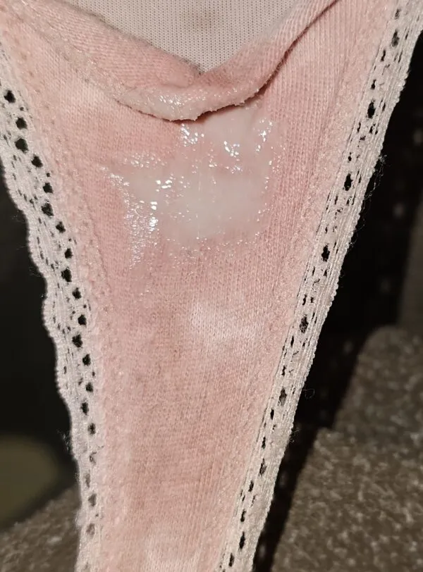 ピンク色のレース付きパンティの股間にべっとりと白濁したマン汁が付着している様子を捉えた女の淫らな股間のアップ画像