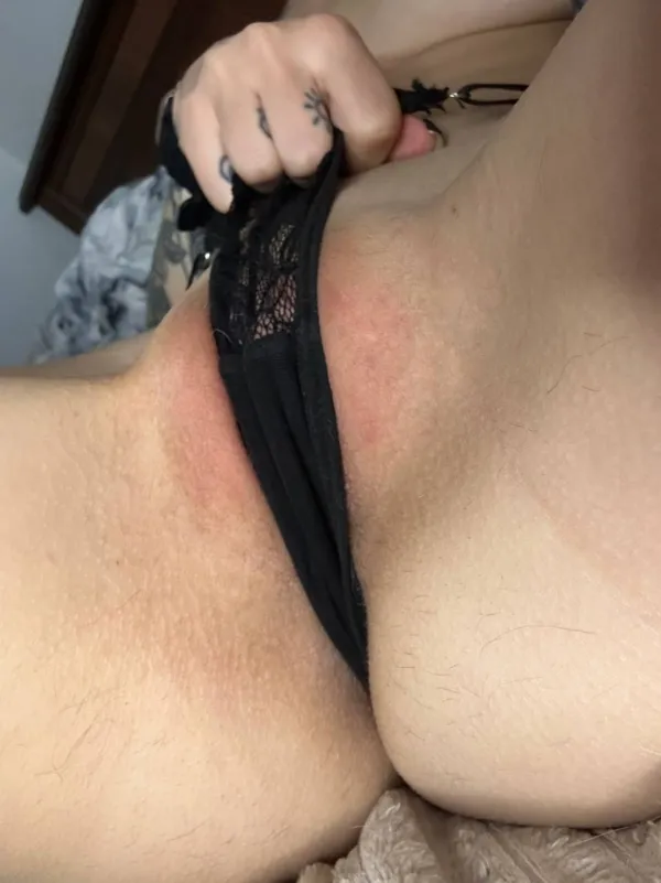 白人美女が仰向けに寝転びながら黒いレースの下着を手で引き下げる動作を捉えたハミマンのエロ画像で、淫らに露出した股間の様子が鮮明に映し出されているシーン。